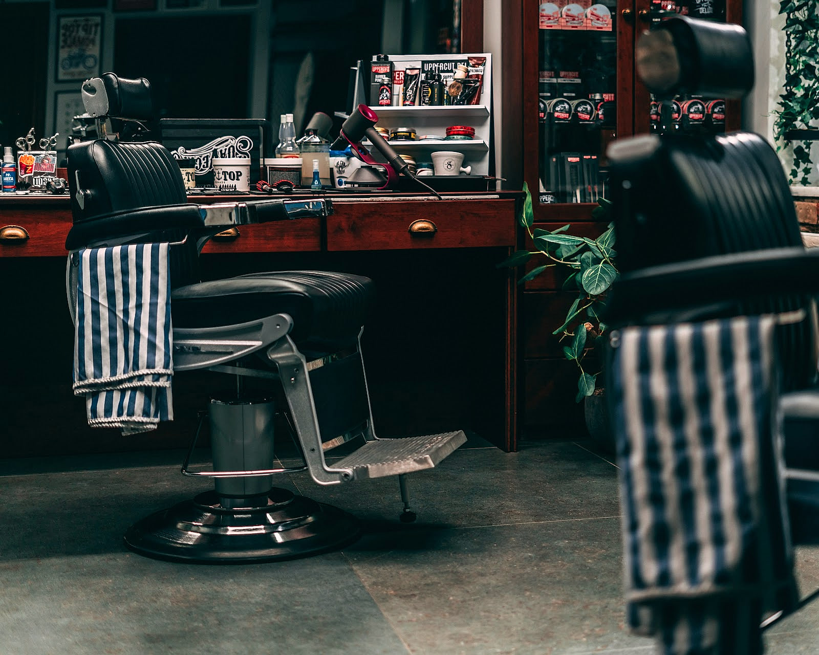 Το εσωτερικό του Nicko Makris Barbershop & Spa: vintage καρέκλες κουρείου και ξύλινο πάγκο.